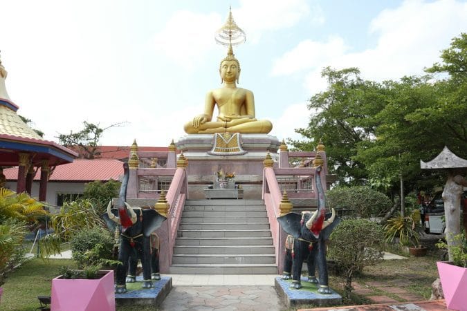 a statue of a buddha sitting on top of a stair case