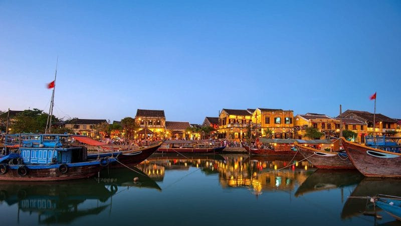 Boats on Calm Water Near Buildings Under Blue Sky