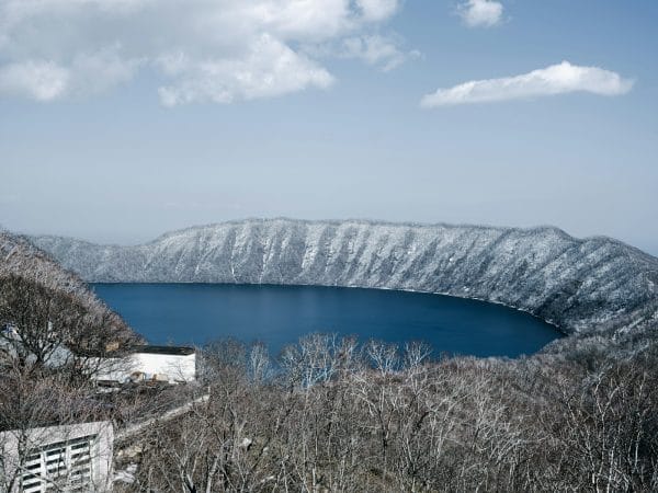 a blue lake surrounded by snow covered mountains